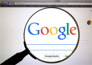 Google home page with magnifying glass over the search bar and logo